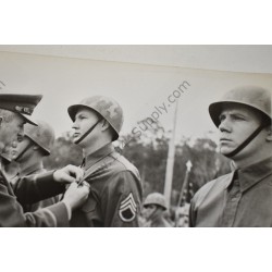 Photo of GI's wearing camouflaged liners at ceremony