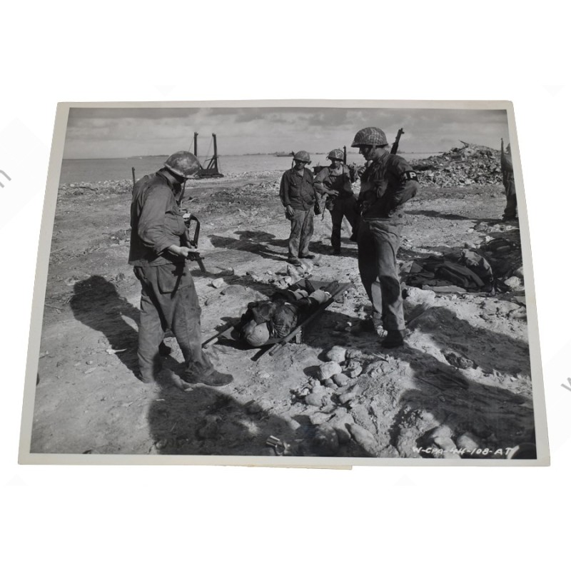 Photo of 7th Division GI's with wounded prisoner at Kwajalein