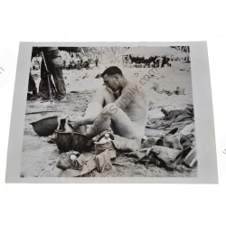 Photo d'un GI prenant un bain dans son casque sur l'île de Makin